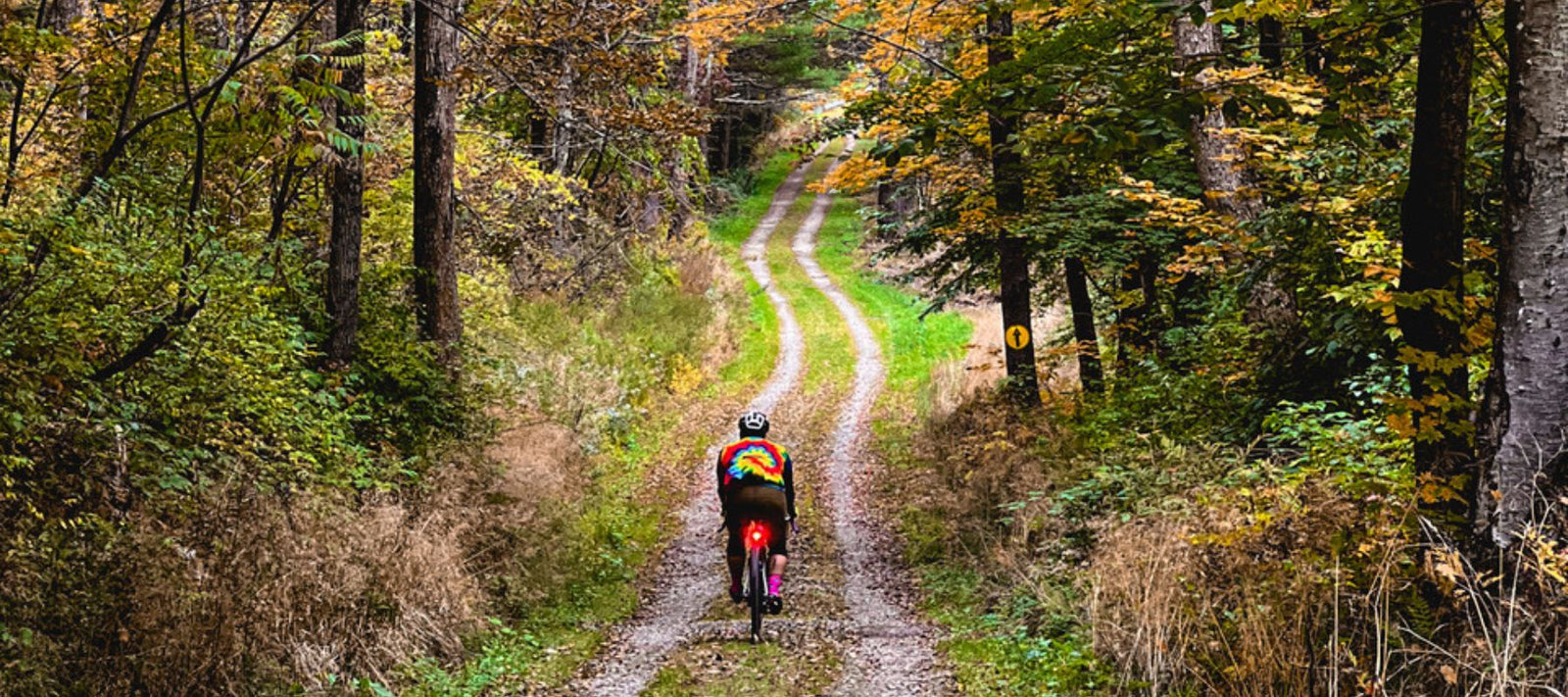 man riding through new england foliage 